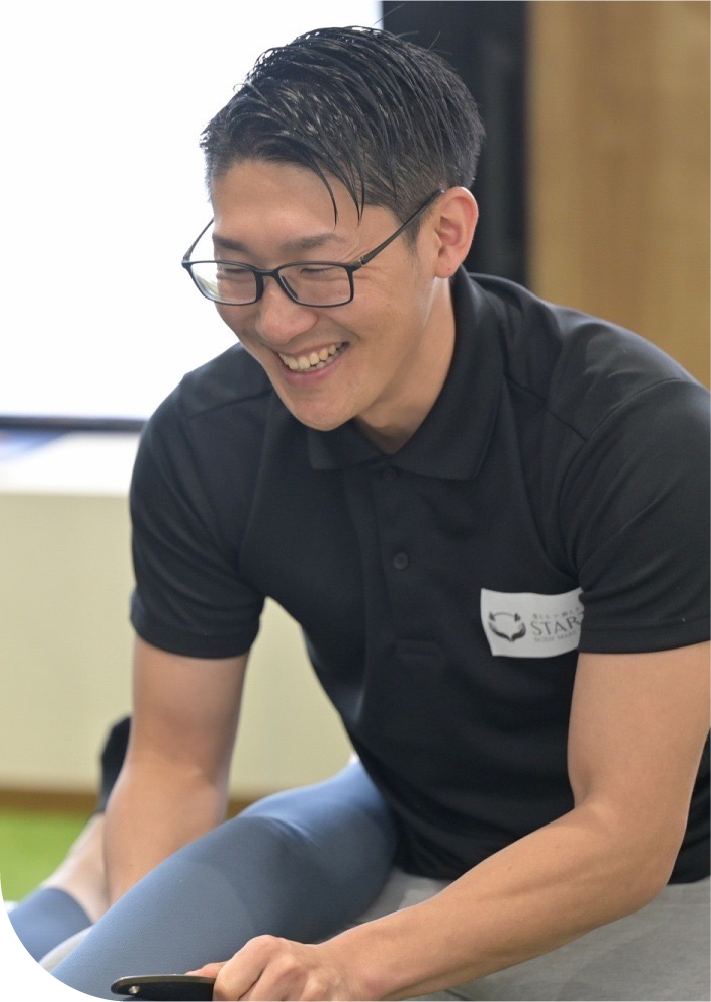 トレーナーが笑顔で指導している様子